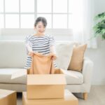 衣類を段ボールに入れる女性