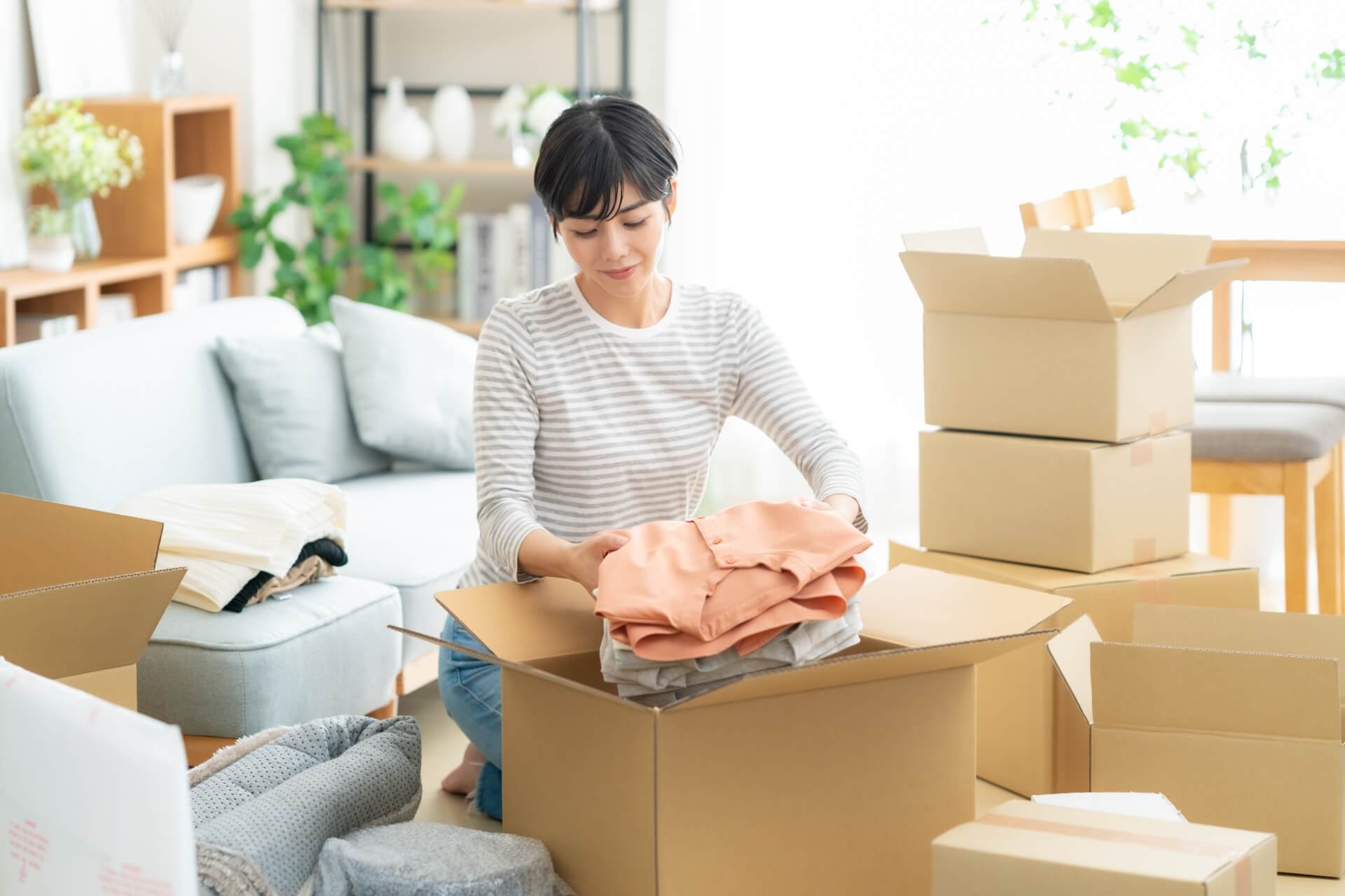 引越しの荷造りをする女性